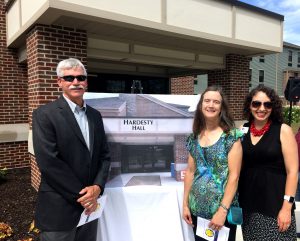 Jim Hardesty’s nephew, Chuck Hardesty, niece, Joan Hardesty, and SCCF Director of Development, Sarah Origer, stand with an artistic rendering of the sign for Hardesty Hall, which will soon grace the dorm’s entrance.